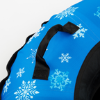 Blue bag with white snowflake patterns and black handles on a white background