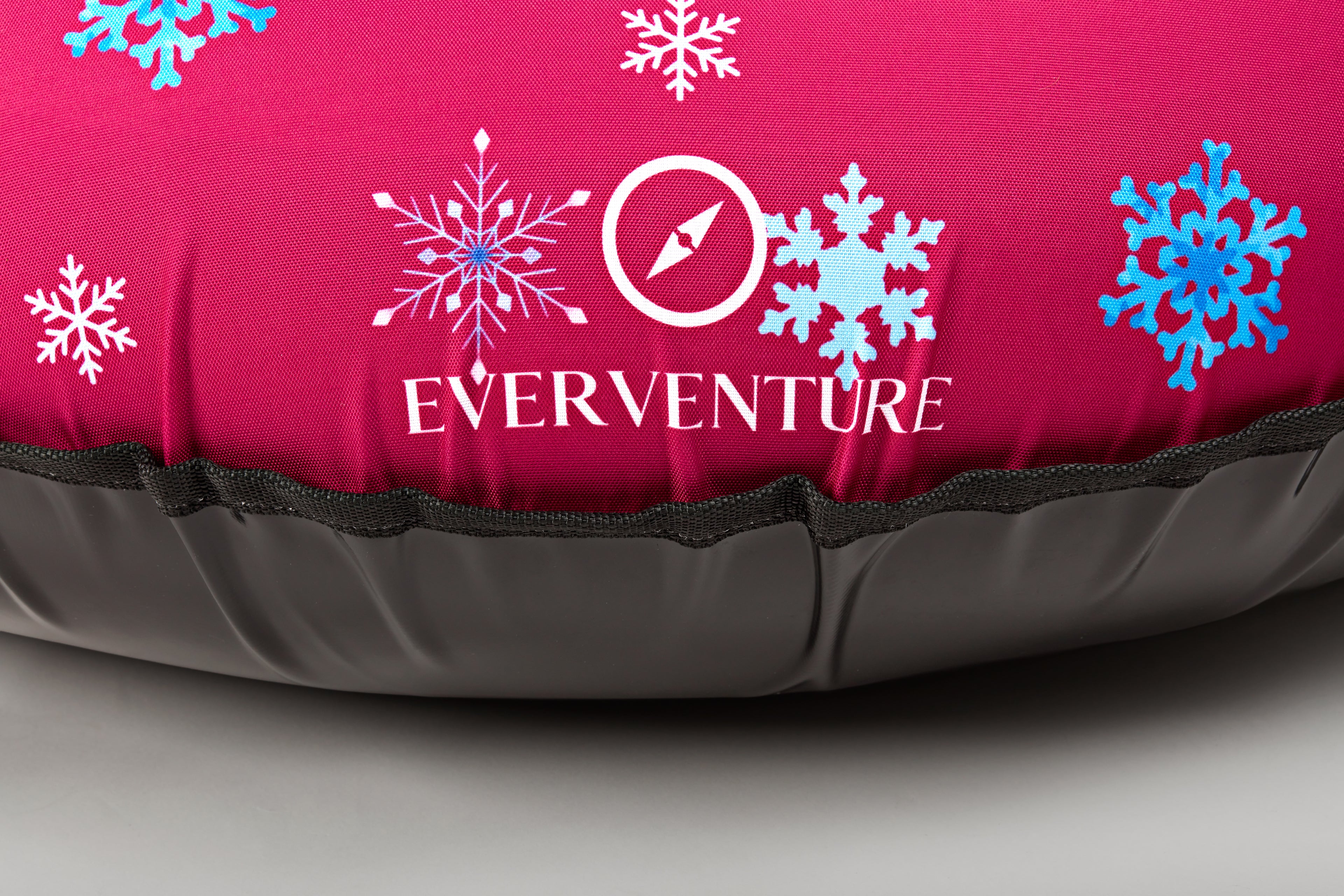 Inflatable sleeping pad with 'Everventure' logo and snowflake designs on a pink background