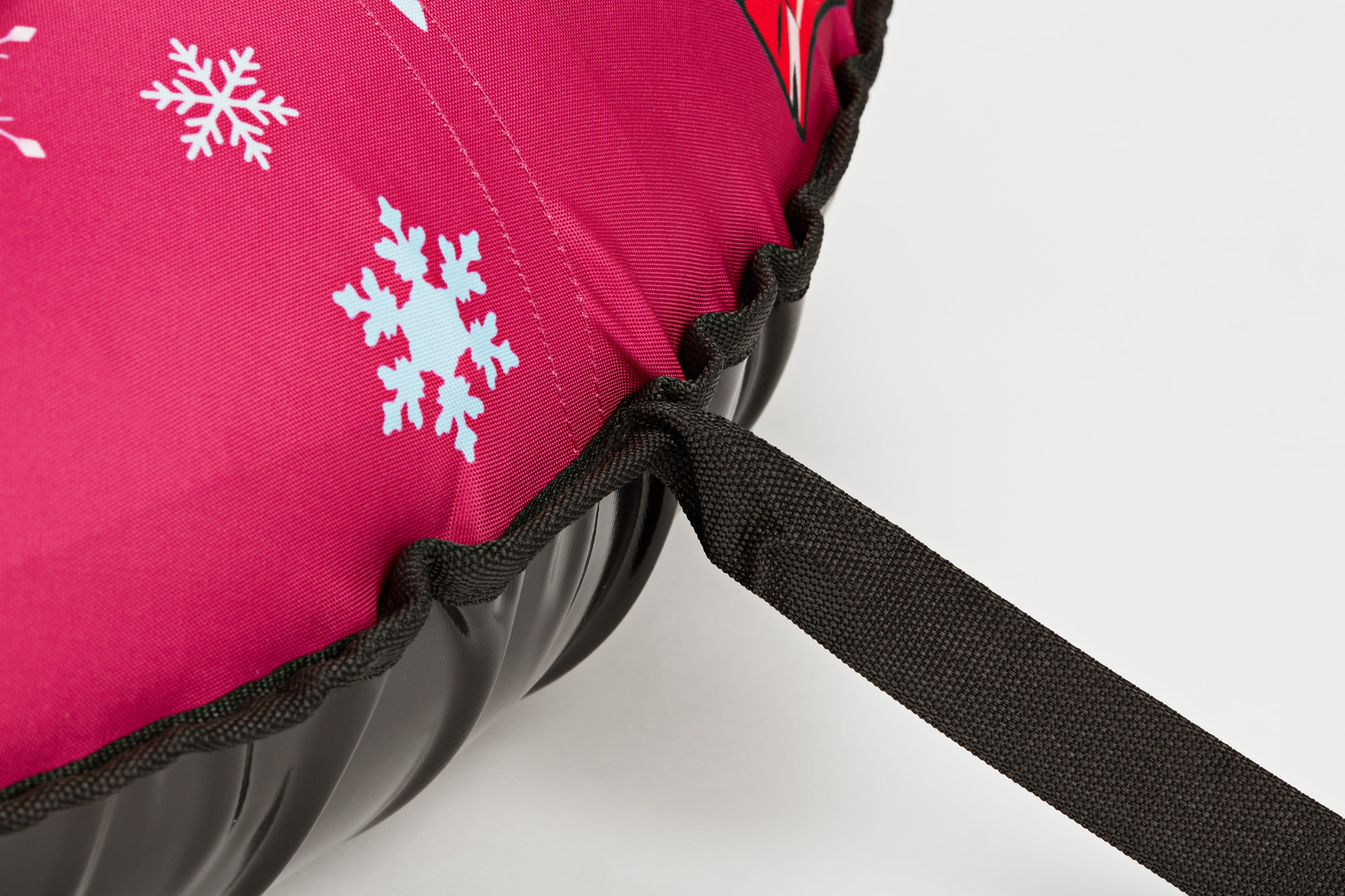 Close-up of a pink fabric with snowflake patterns and a black strap on a white background